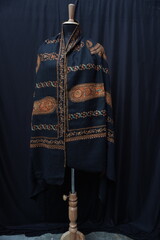Elegant display of Kashmiri shawls draped on a mannequin, featuring intricate Sozni embroidery that...
