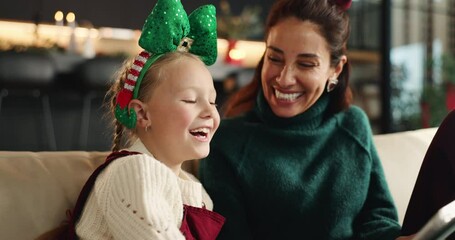 Christmas, mother and child laughing with tablet on sofa for festive meme, joke or family talking. Xmas, happy kid and mom with tech in home for funny game, story and bonding on holiday with parent - Powered by Adobe