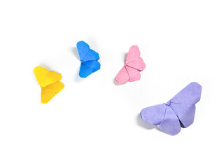 Origami paper butterflies in purple, pink, blue and yellow on a white background.
