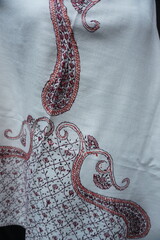 Elegant display of Kashmiri shawls draped on a mannequin, featuring intricate Sozni embroidery that...