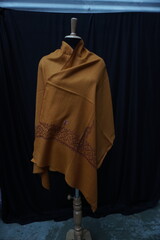 Elegant display of Kashmiri shawls draped on a mannequin, featuring intricate Sozni embroidery that...