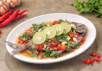 A Chinese Steamed Fish topped with Ginger and Shallots and seasonings, with hot oil poured over it to create a dramatic sizzle and an amazing sauce.
