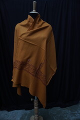 Elegant display of Kashmiri shawls draped on a mannequin, featuring intricate Sozni embroidery that...