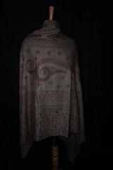 Elegant display of Kashmiri shawls draped on a mannequin, featuring intricate Sozni embroidery that...