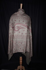 Elegant display of Kashmiri shawls draped on a mannequin, featuring intricate Sozni embroidery that...