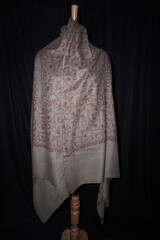 Elegant display of Kashmiri shawls draped on a mannequin, featuring intricate Sozni embroidery that...