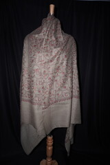 Elegant display of Kashmiri shawls draped on a mannequin, featuring intricate Sozni embroidery that...