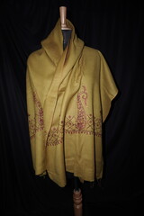 Elegant display of Kashmiri shawls draped on a mannequin, featuring intricate Sozni embroidery that...