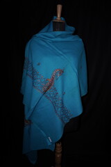 Elegant display of Kashmiri shawls draped on a mannequin, featuring intricate Sozni embroidery that...