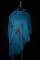 Elegant display of Kashmiri shawls draped on a mannequin, featuring intricate Sozni embroidery that...