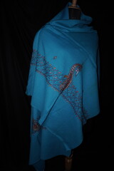 Elegant display of Kashmiri shawls draped on a mannequin, featuring intricate Sozni embroidery that...