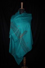 Elegant display of Kashmiri shawls draped on a mannequin, featuring intricate Sozni embroidery that...