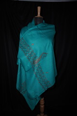 Elegant display of Kashmiri shawls draped on a mannequin, featuring intricate Sozni embroidery that...