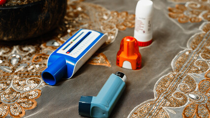 Assorted Inhalers and Medication Devices on Decorative Fabric Surface