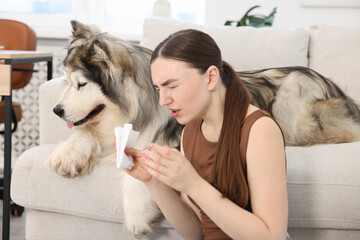 Woman suffering from allergy with her dog at home