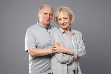 Portrait of lovely senior couple on grey background
