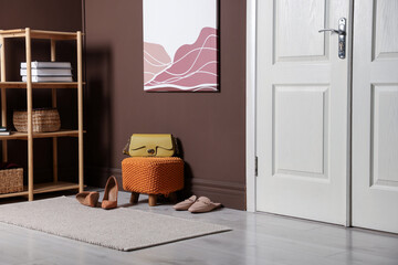 Stylish pouf with bag and shoes at home