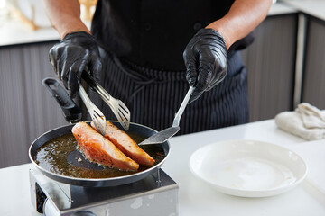 chef cooking salmon steaks in the kitchen