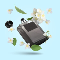 Bottle of floral perfume and jasmine flowers in air on light blue background