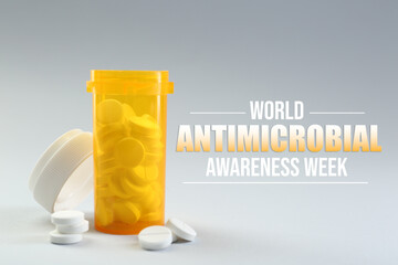 World antibiotic awareness week. Bottle and scattered pills on grey background