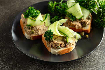Open sandwiches with pate, fresh cucumber, capers, and parsley.