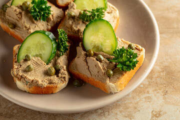 Open sandwiches with pate, cucumber, capers, and parsley.