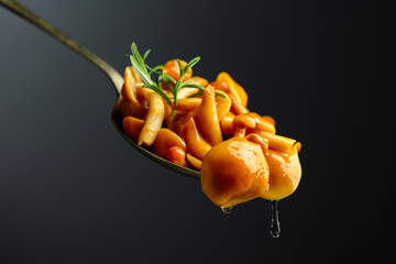 Homemade pickled honey mushrooms in spoon.