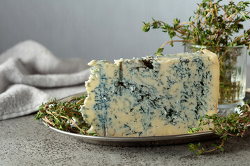 Gorgonzola and thyme on a gray stone table.
