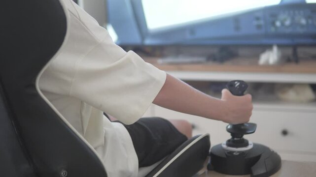 Young boy in a modern living room playing a flight simulator video game with a joystick, training to become a pilot