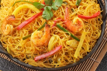 Singapore Mei Fun consists of rice vermicelli seasoned with curry powder, soy sauce and stir-fried with egg, shrimp