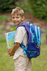Cute first grade school child,  going to school. First day at school for a firstgrader, child starting school, bringing flowers for the teacher