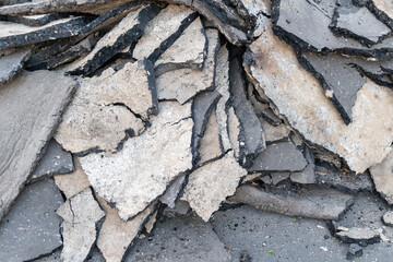 Close-up of broken asphalt and concrete pieces on road surface