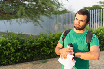 Athletic man checking time during fitness workout outdoors