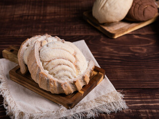 Concha breads, dusted with sugar, rest on a rustic wooden board