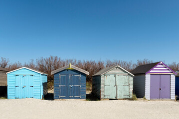 Blue, green and purple beach huts