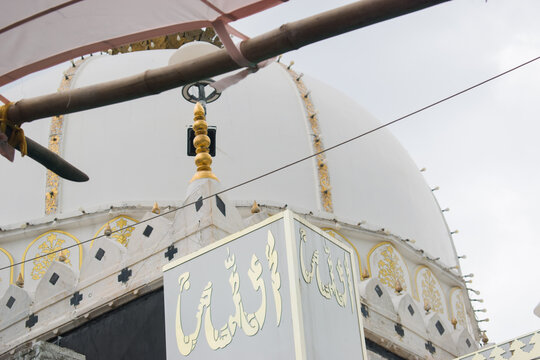 "Allah" in urdu means God of Muslim written on the iconic white marble dome of the Ajmer Sharif Dargah. Cultural and religious heritage of the site, often visited by pilgrims across India and abroad.