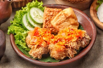 Ayam geprek is a typical Indonesian fried chicken dish with flour that is mashed or mashed with plow chili sauce