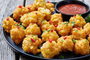 corn nuggets on a plate with tomato sauce