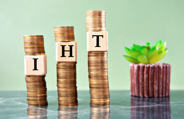 IHT - acronym on wooden cubes on stacks of coins