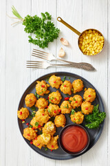 corn nuggets on a plate with tomato sauce
