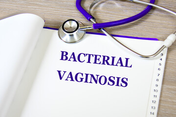 BACTERIAL VAGINASIS - words on a white sheet against the background of a stethoscope