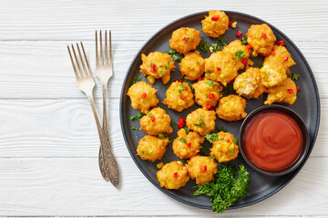 corn nuggets on a plate with tomato sauce
