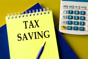 TAX SAVING - words on a yellow notepad with a calculator