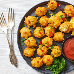 corn nuggets on a plate with tomato sauce