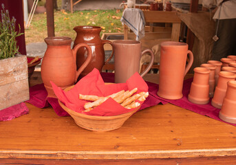 Medieval-style market stand with clay mugs, breadsticks, and rustic decor in Bavaria