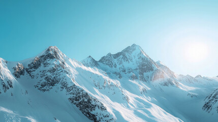 Obraz premium Snowy mountain ranges rise majestically against a bright blue sky, with sunlight glistening off their peaks. This serene winter landscape invites tranquility and awe amidst nature's grandeur