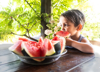 Child Eating Juicy Red Watermelon at Garden Table Surrounded by Greenery — Healthy Eating in Action