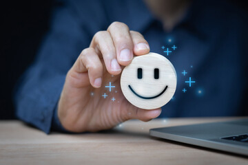 User hand holds up a wooden circular token with a hand-drawn smiling face on it and blue, glowing...