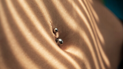 A navel piercing in the skin surrounding the navel or belly button
