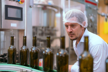 Two professionals discussing wine bottling process inside a modern winery facility in the afternoon